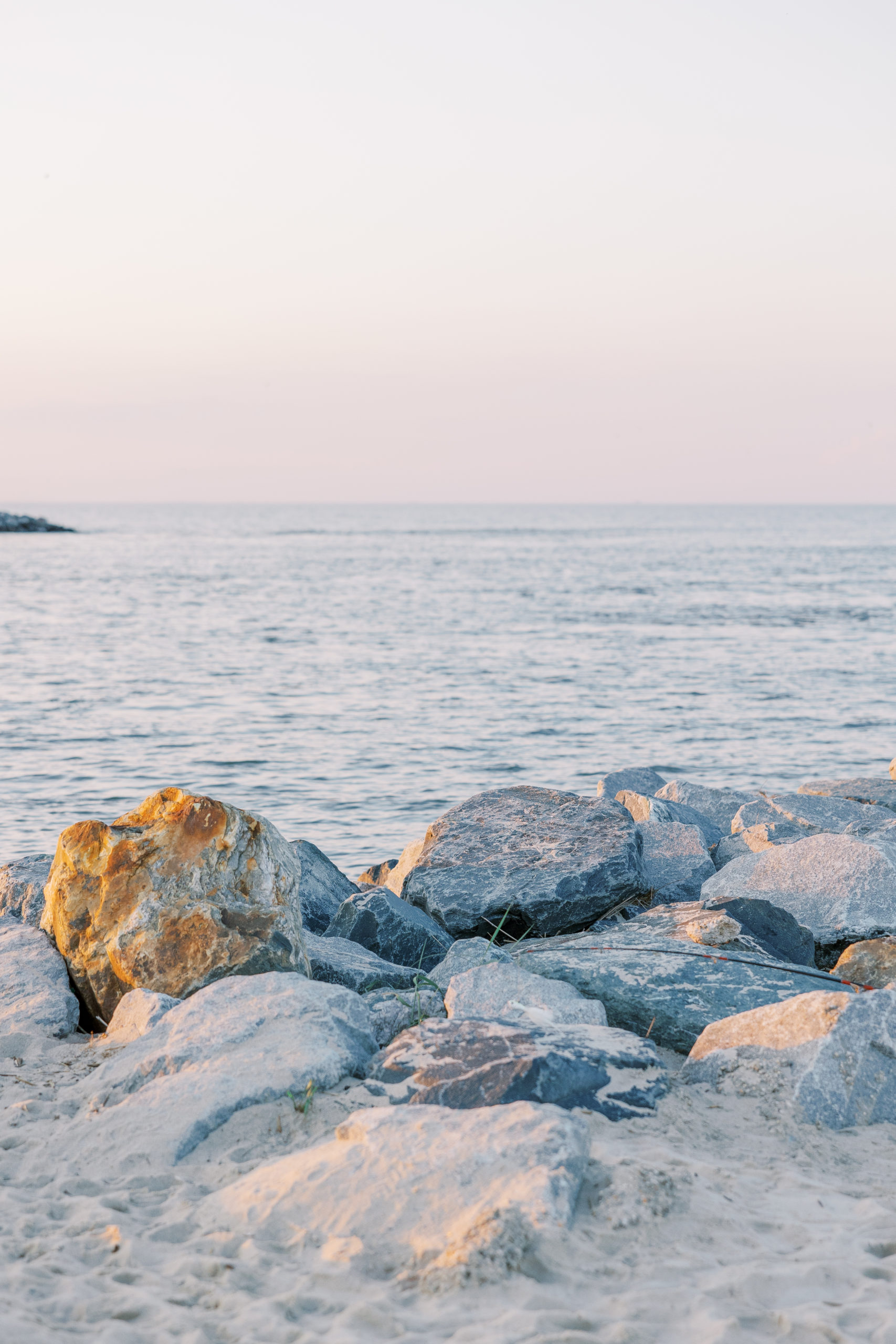View of jetty rocks on the beach at sunset for Summer Lewes Engagement Session
