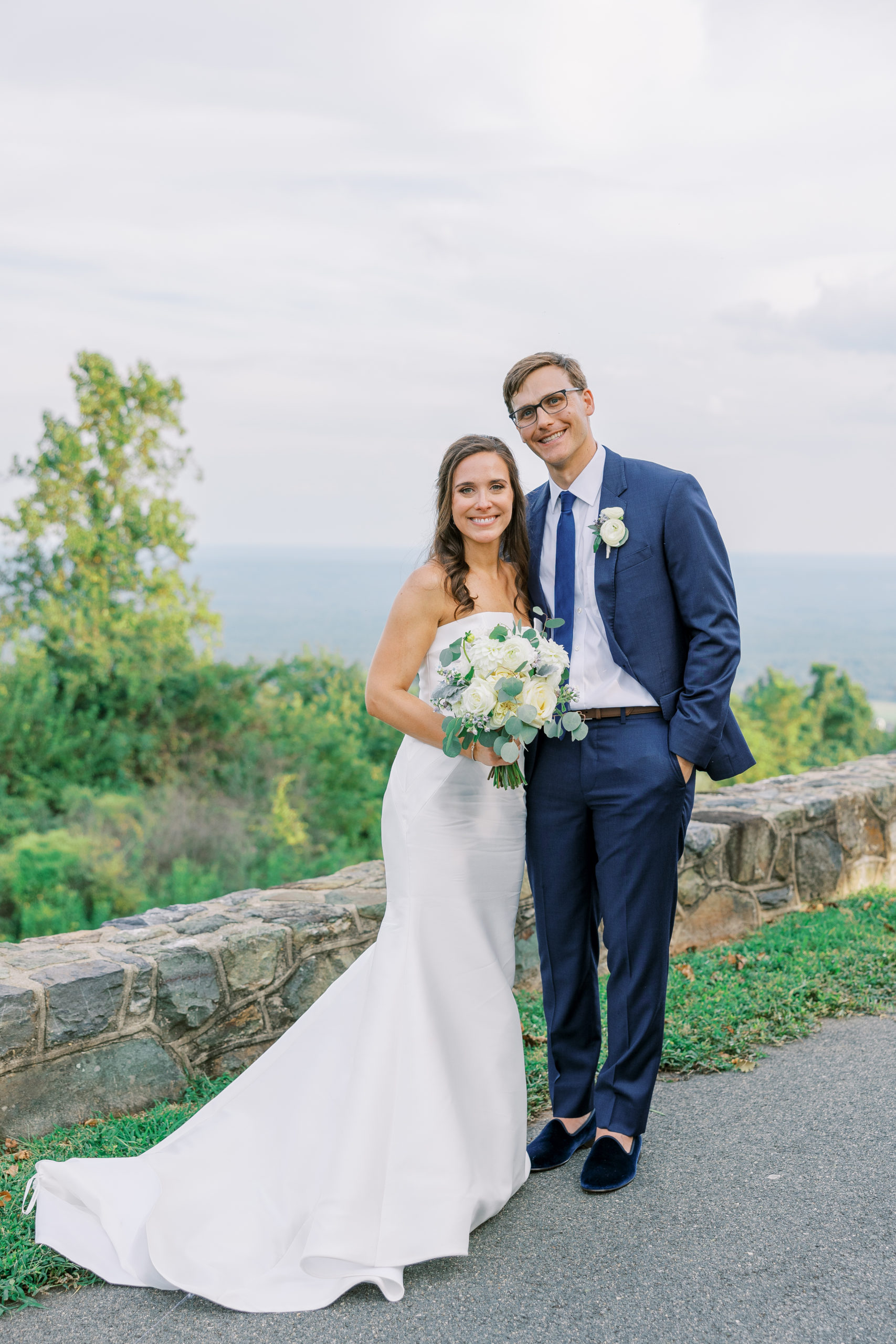 Bride and groom pose and smile atop green mountainside for Charlottesville Wedding Photography
