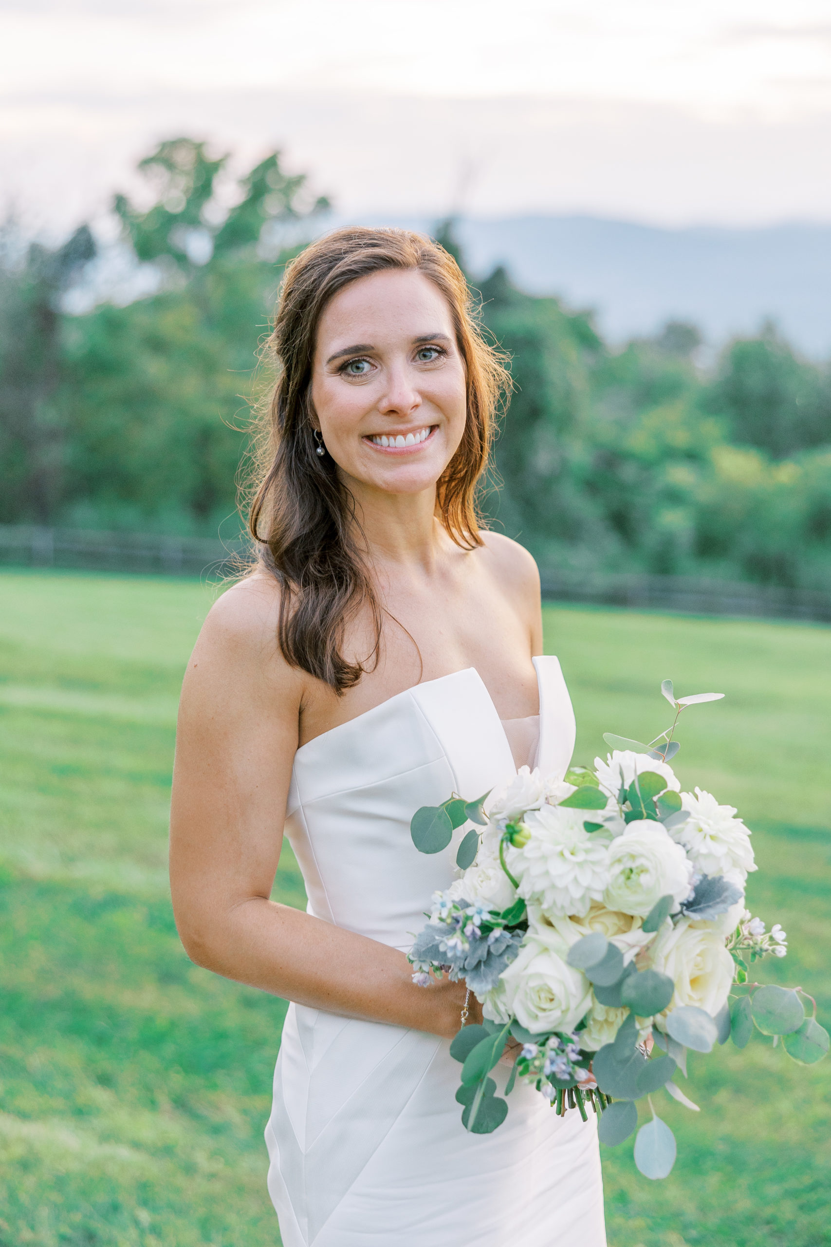 Bride smiles and holds her white rose bouquet for Charlottesville Wedding Photography
