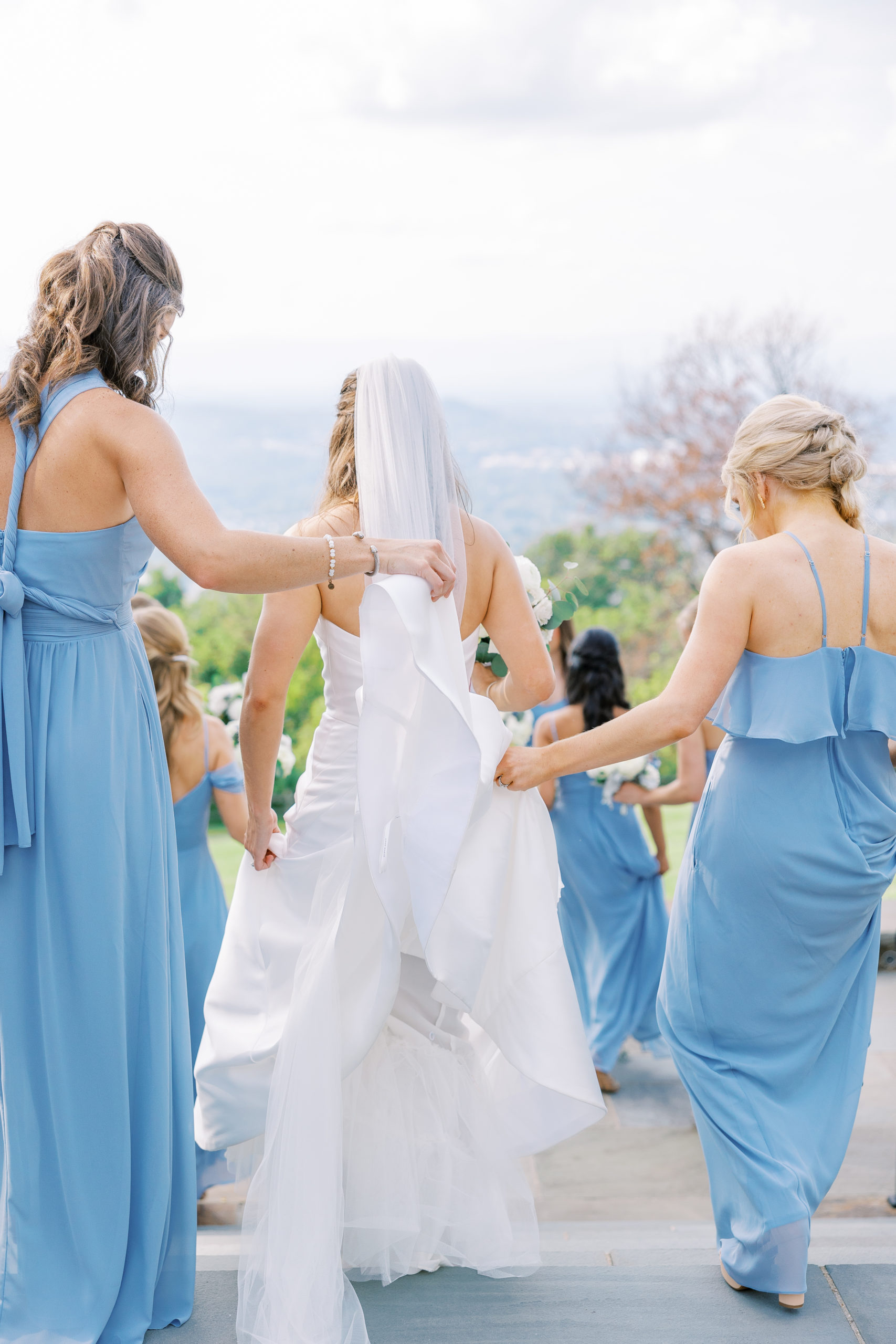 Bridesmaids help bride walk down stairs to walk down the aisle for Charlottesville Wedding Photography
