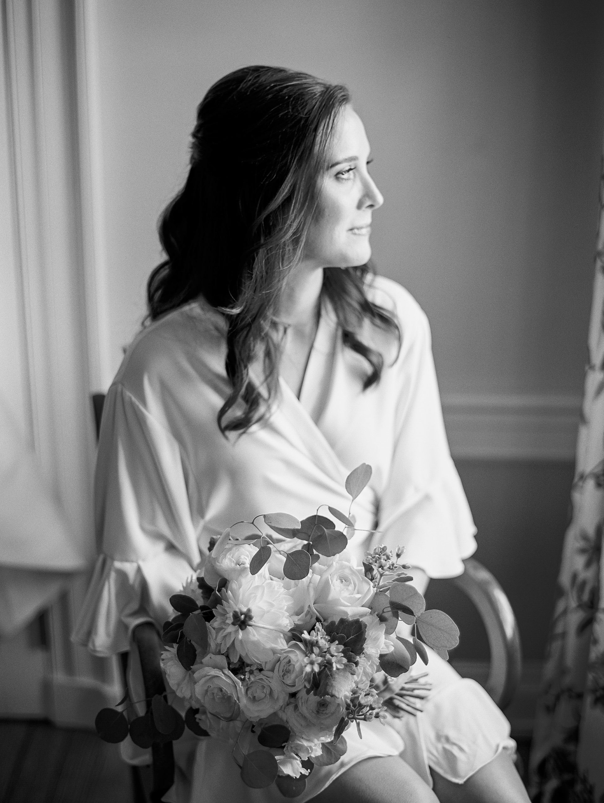 Bride looks to the side in robe holding wedding bouquet for Charlottesville Wedding Photography
