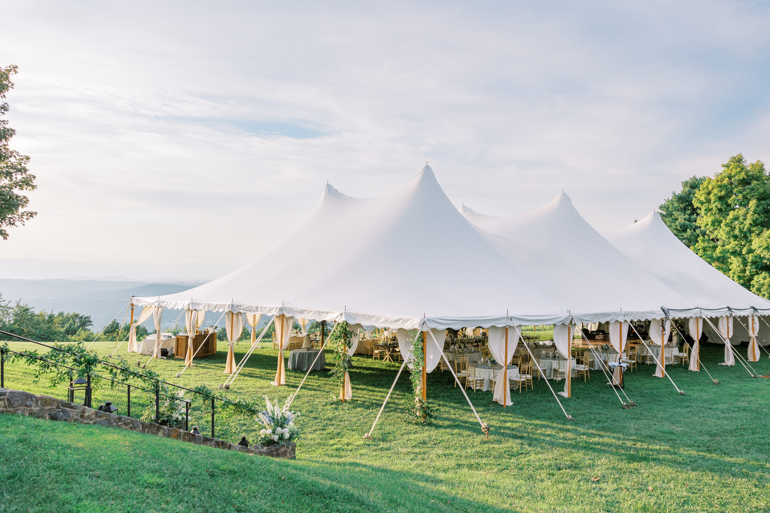 White reception tent on law with foliage and light blue cloudy skies for Charlottesville Wedding Photography
