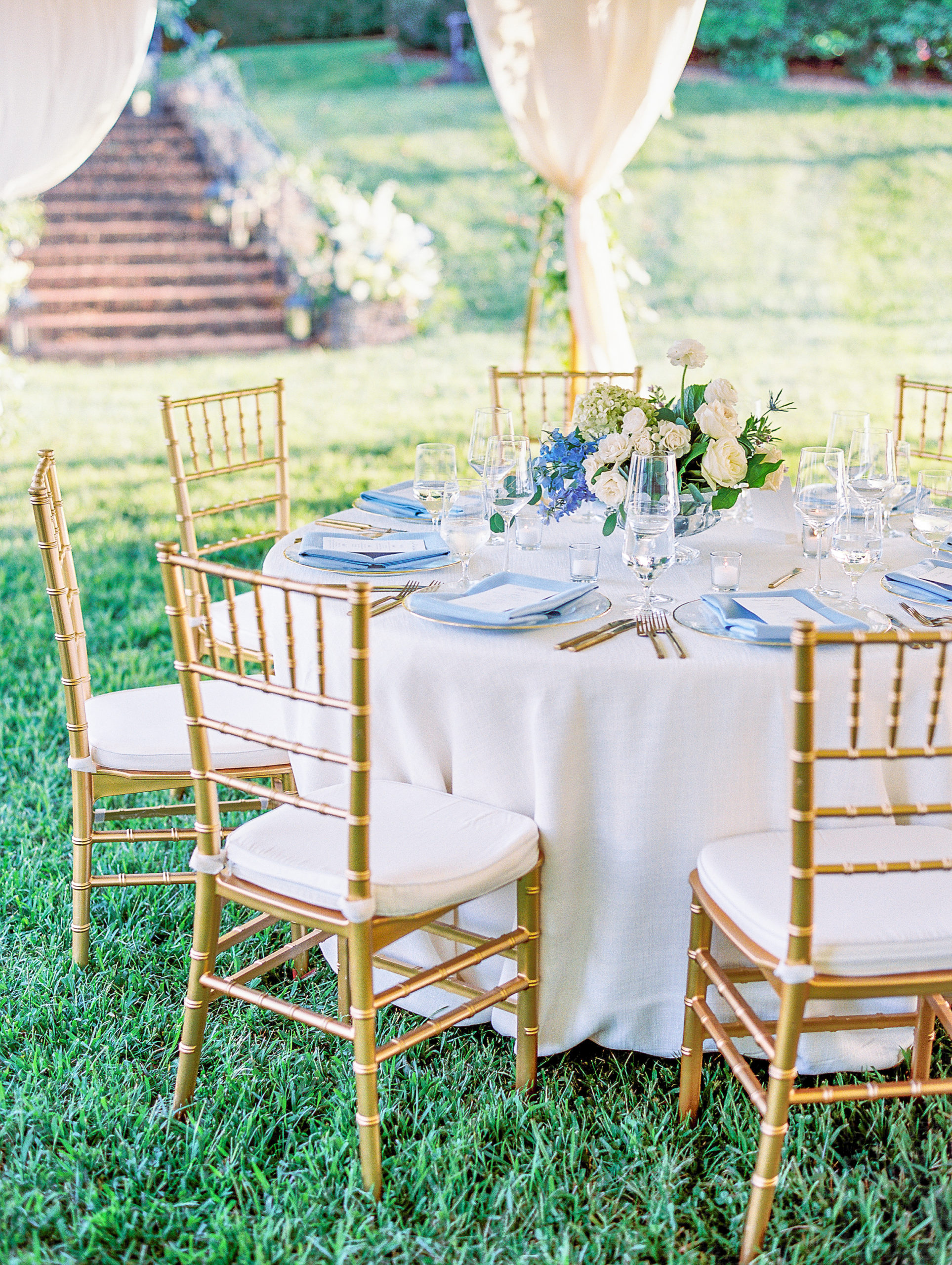 Round white table for wedding reception with light blue napkins and gold utensils for Charlottesville Wedding Photography
