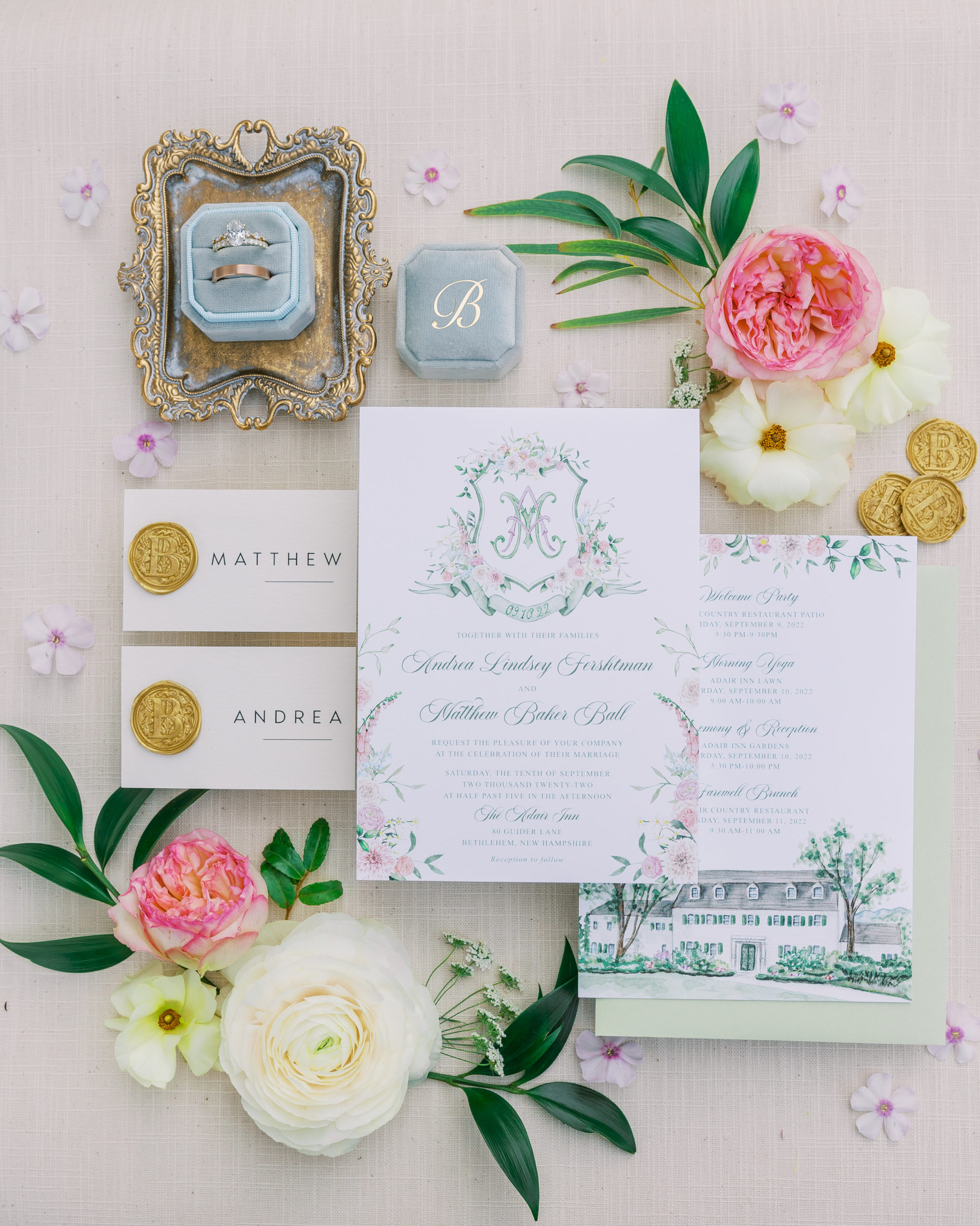 Watercolored invitation suite with rings and various flowers 