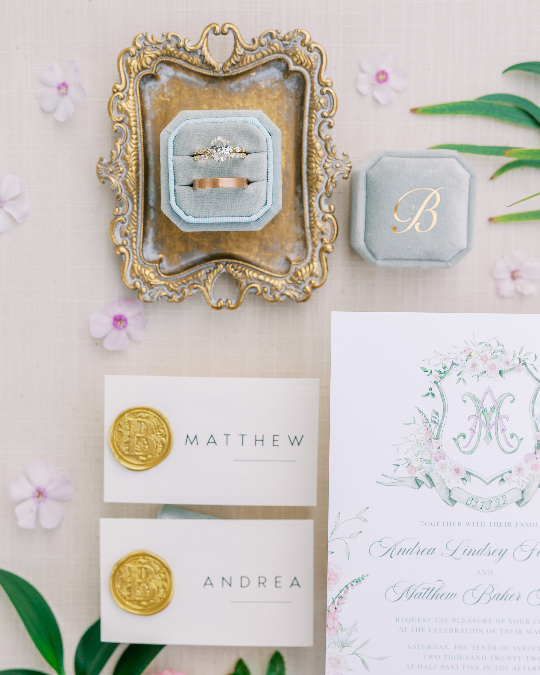Wedding rings on small gold tray, blu ring box, name tags with wax seal and invitation for New Hampshire Wedding Photography