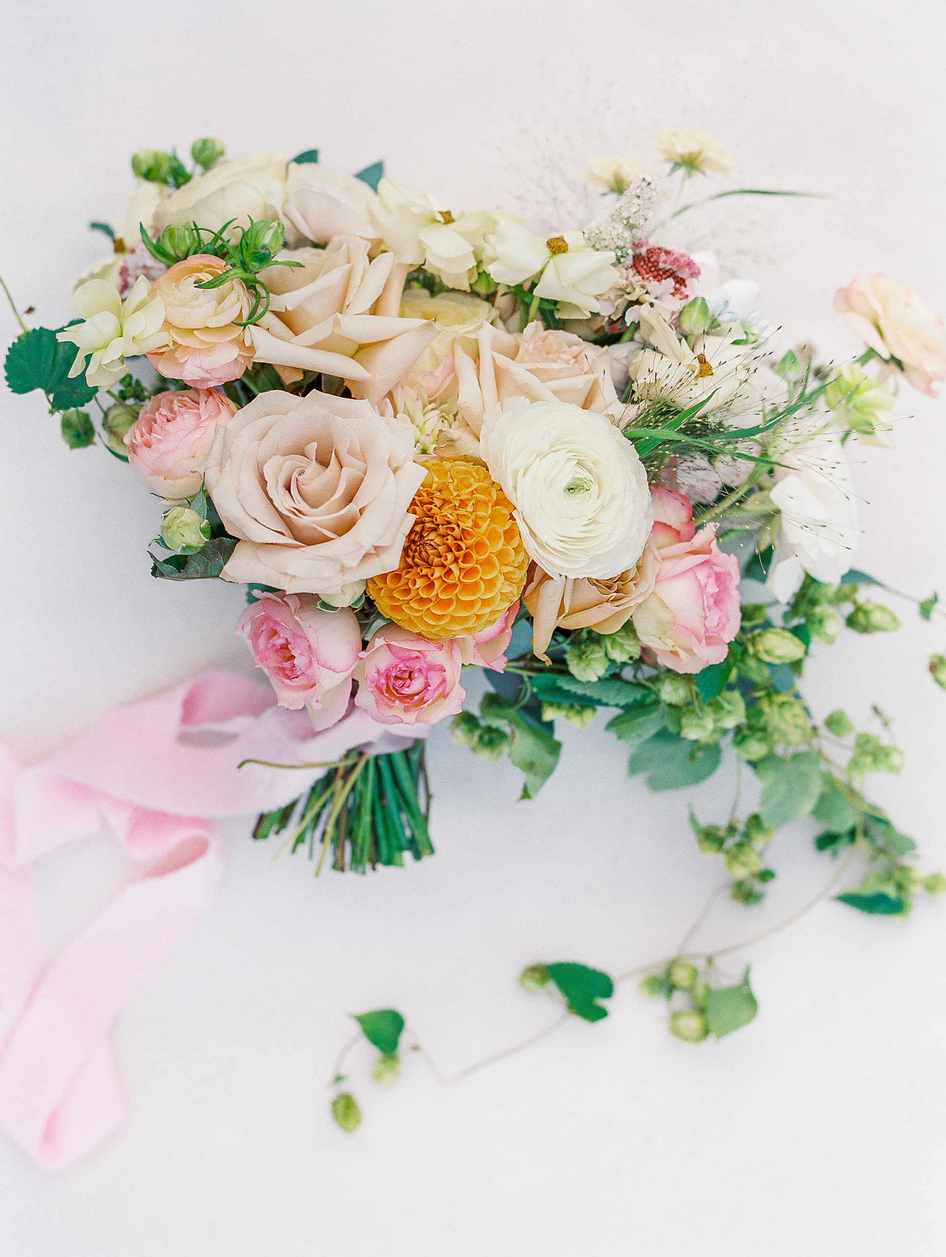 Bride's bouquet of roses and various other neutral and pink tones with pink ribbon 
