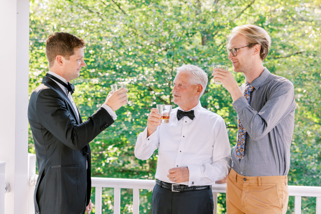 Groom and family raise a glass while getting ready for wedding for New Hampshire Wedding Photography