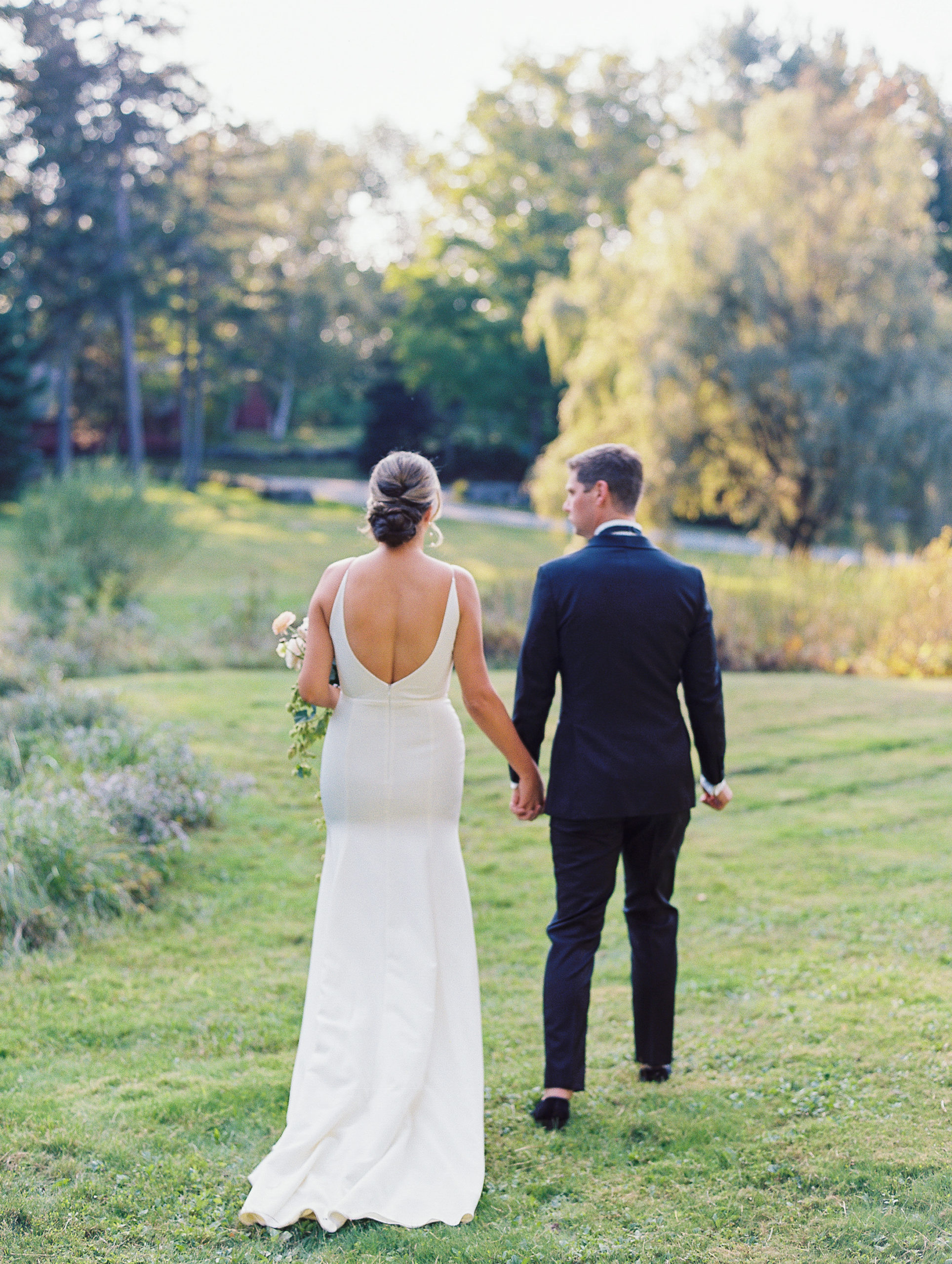 Bride and groom hold hands and walk away outside for New Hampshire Wedding Photography