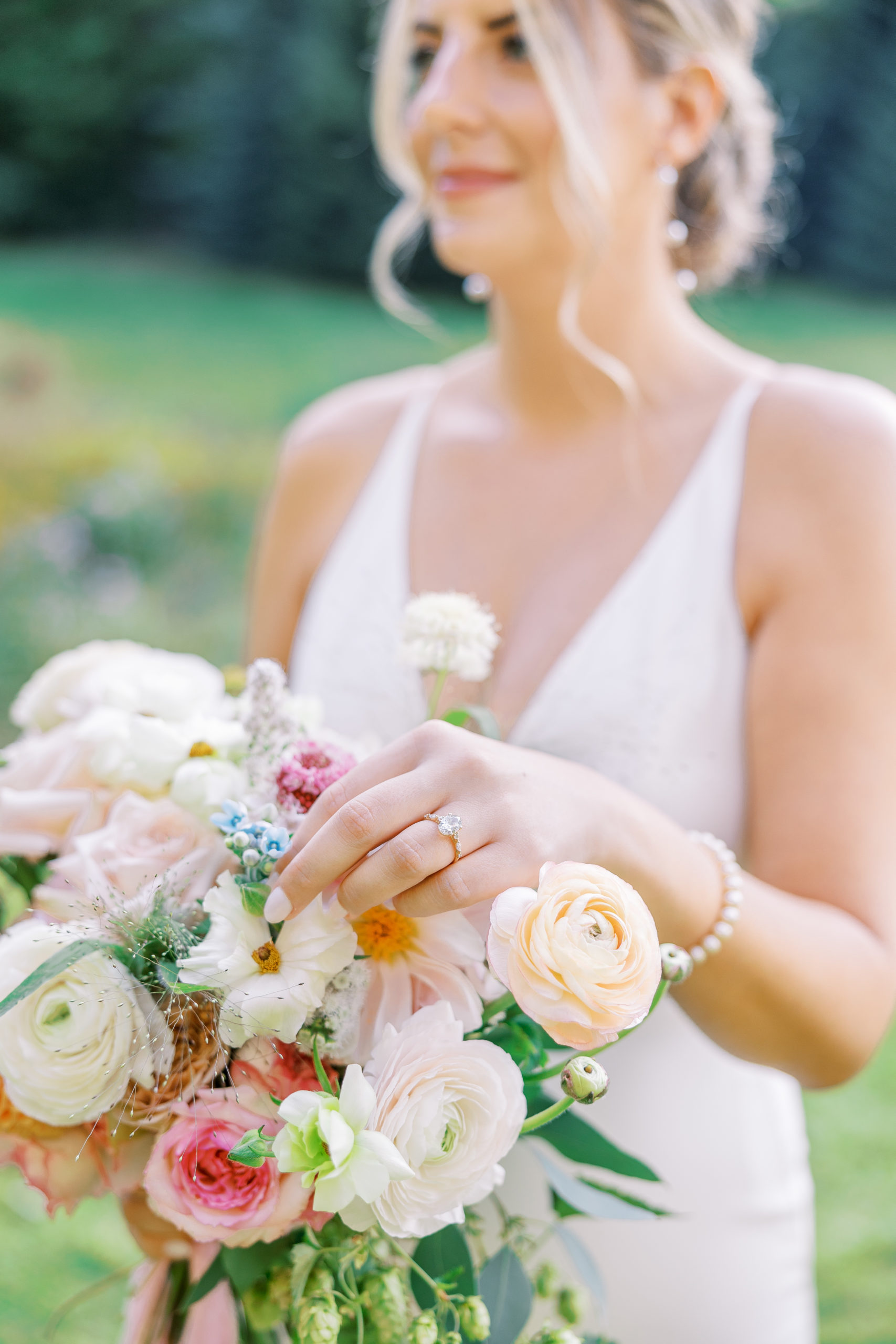 Bride admires flower bouquet for New Hampshire Wedding Photography