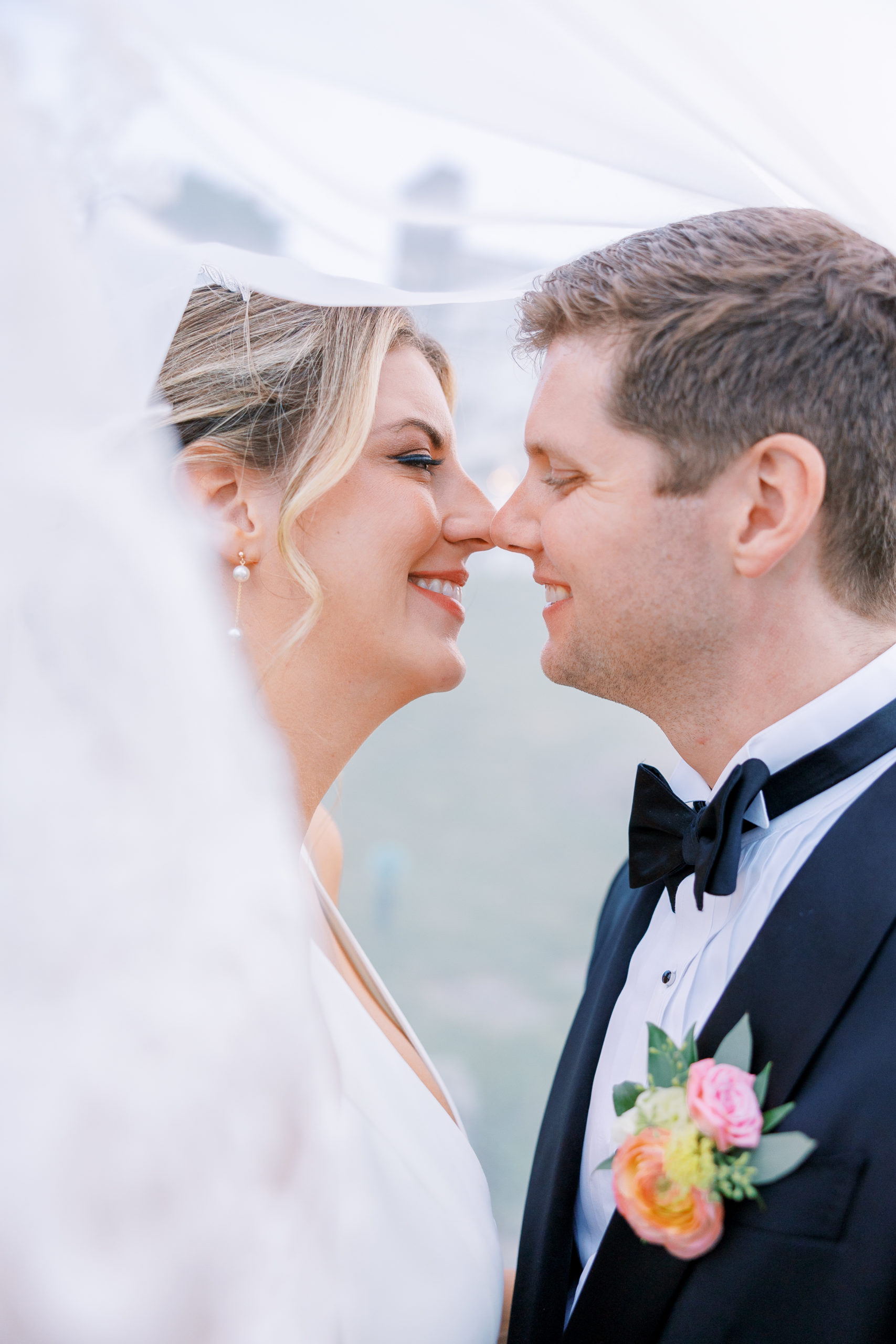 Bride and groom lean in for a kiss underneath bride's vail for New Hampshire Wedding Photography