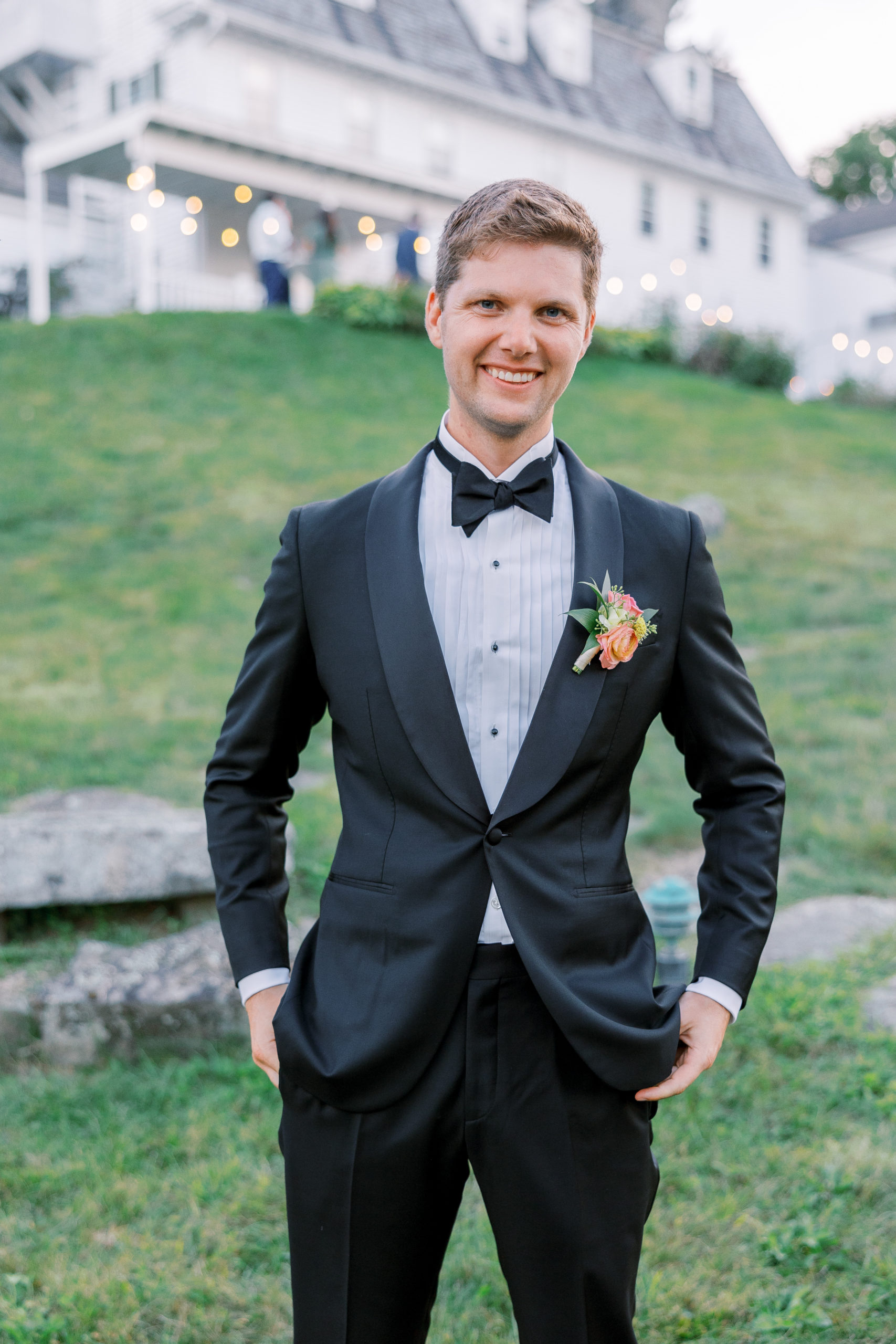 Groom poses with his hands in his pocket outside of reception area 