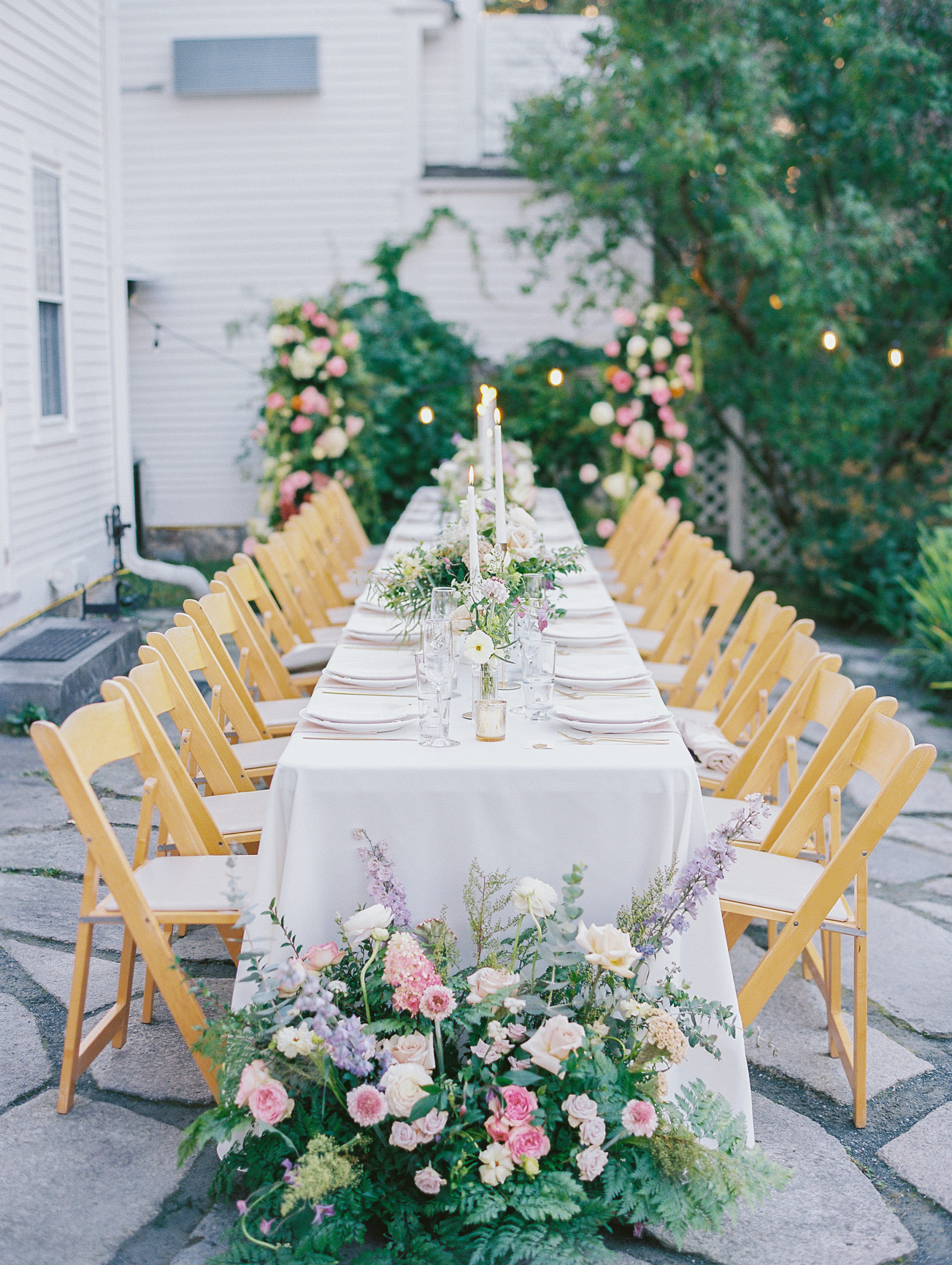 Wedding reception seating, long table with tall candles, and pink, cream, and purple flowers for New Hampshire Wedding Photography