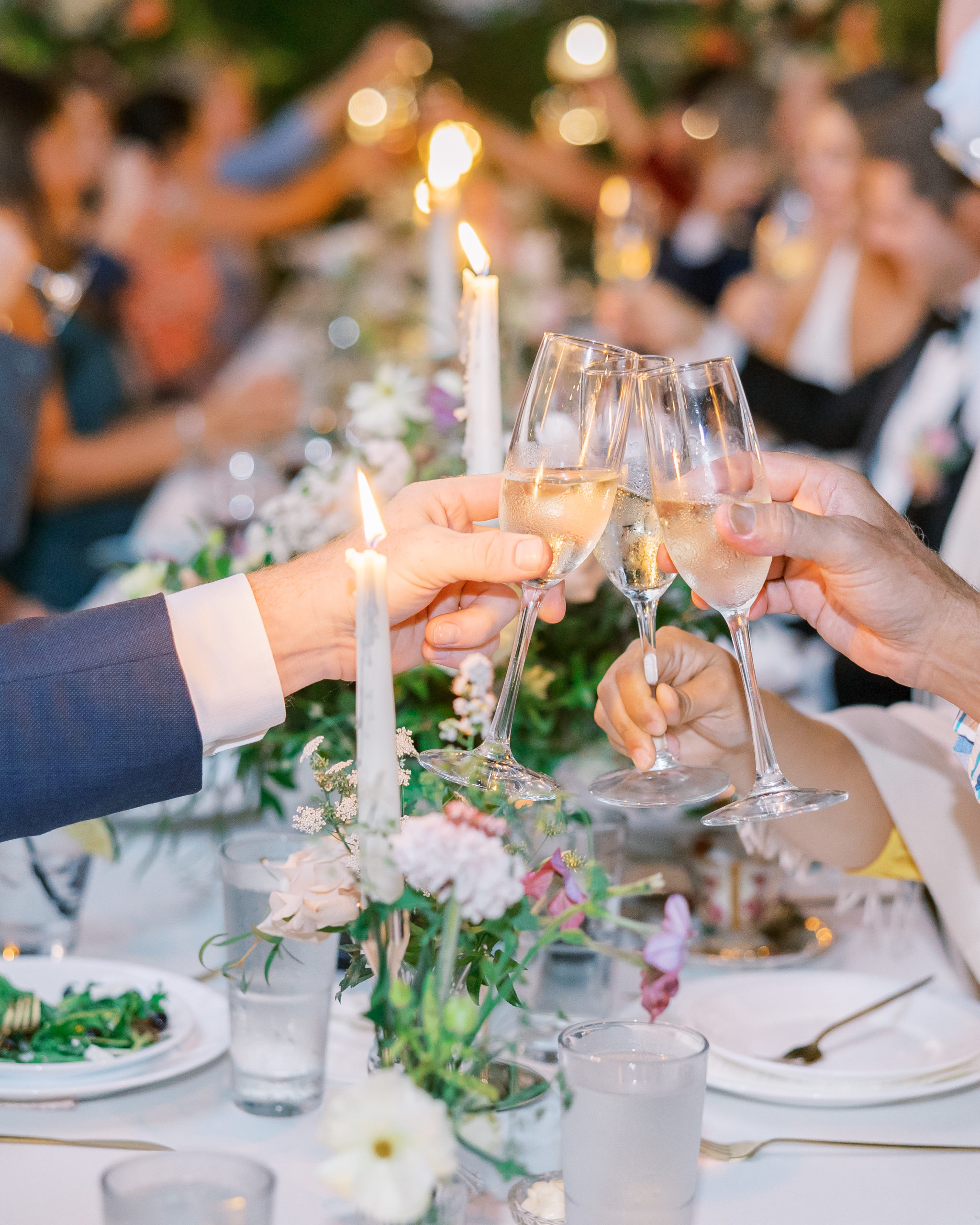 Champagne cheers at reception dinner with tall candles and flowers for New Hampshire Wedding Photography