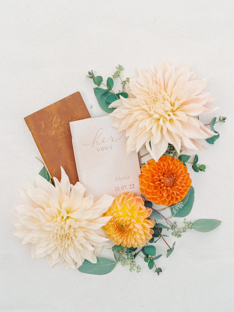 His and Hers vow display with cream, yellow, and orange flowers for Terrain at Styer's Wedding