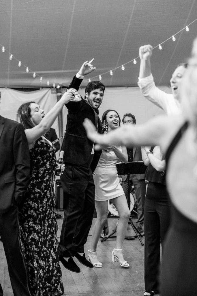 Bride and groom jump and dance with guests on dance floor for Clifton wedding photography