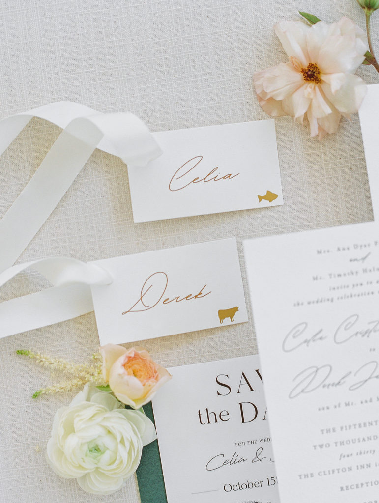 Names Celia and Derek with flowers and invitations on cream paper for Clifton wedding photography