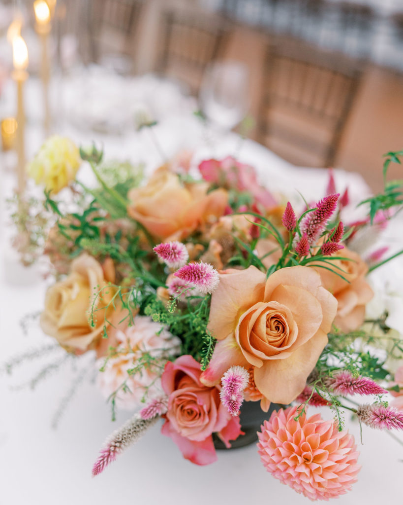 Reception table flower arrangement of peach and pink flowers 