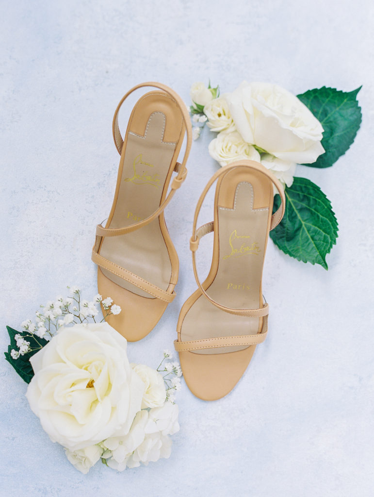 Tan strap high heels with white roses on blue background for California Grill Wedding