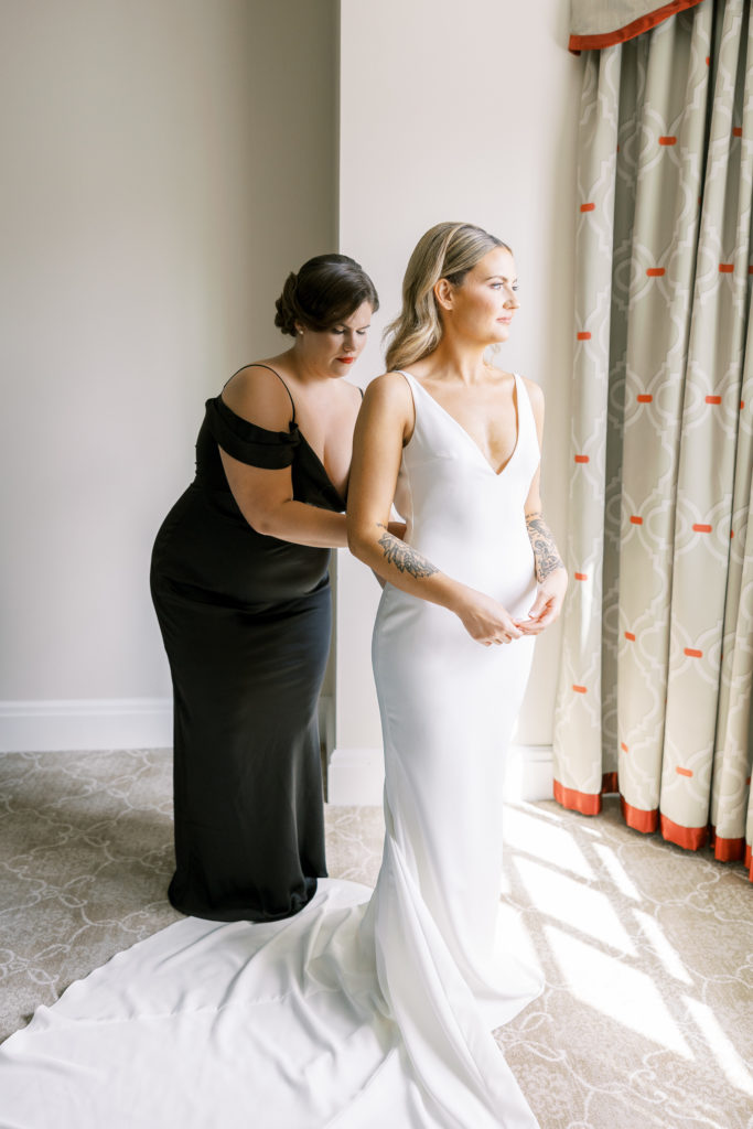 Bride receives help with zipper of wedding dress  
