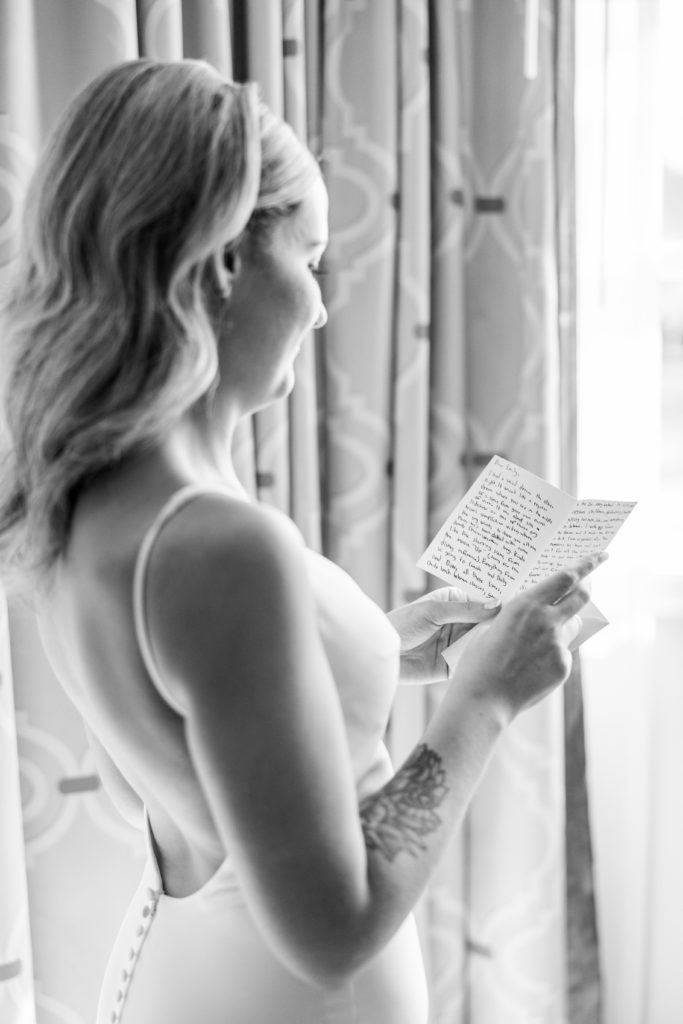 Bride reads letter in wedding dress for California Grill Wedding