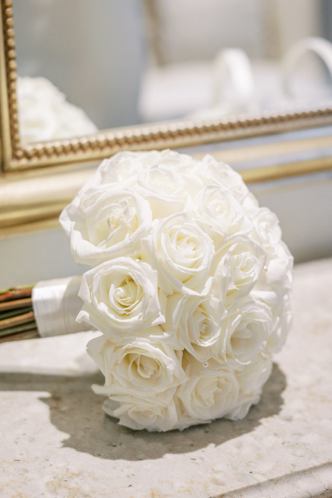 Wedding bouquet of white roses sitting on granite counter for Disney Film Wedding Photographer