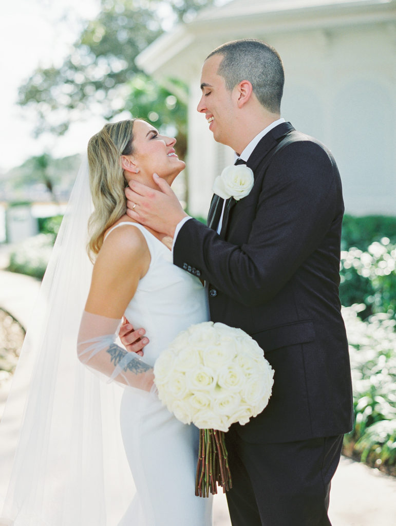 Groom embraces bride and they smile and laugh for Disney Film Wedding Photographer