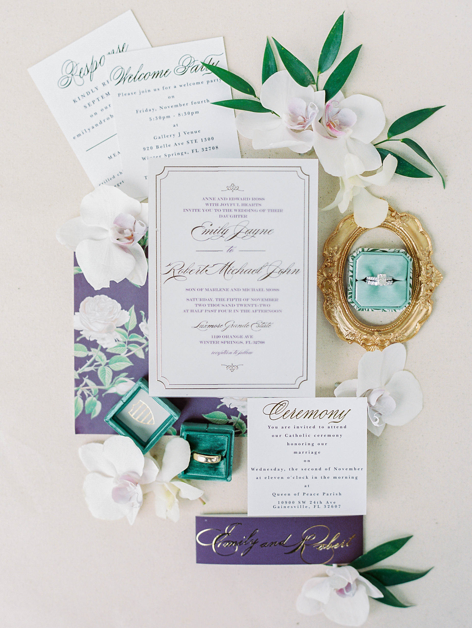 Invitation flat lay with delicate calligraphy and green ring box, and white flowers for Luxmore Grande Wedding