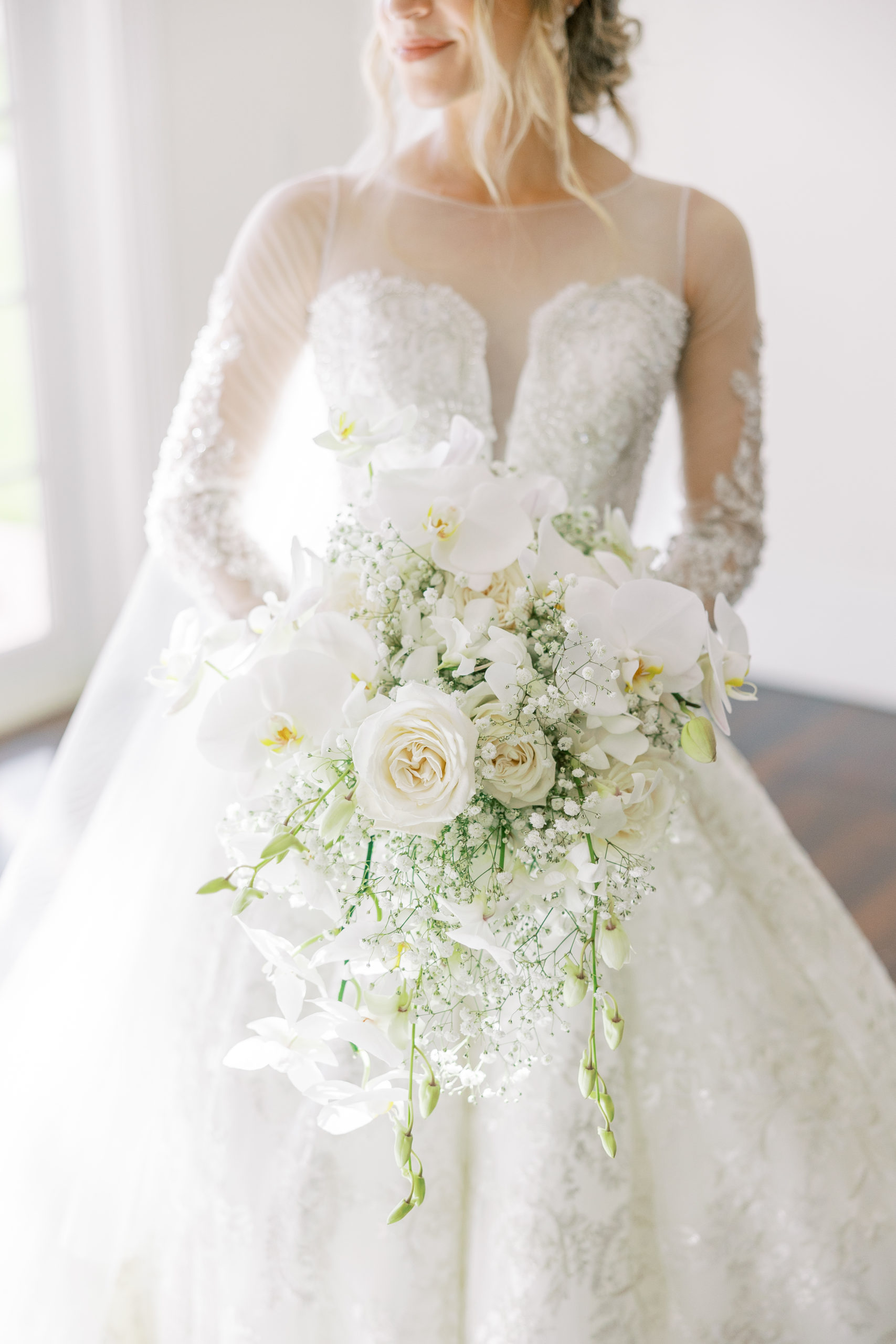 View of bride's white flower bouquet  and details of dress for Luxmore Grande Wedding