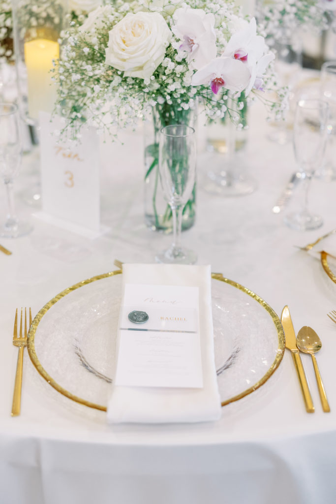 Reception place setting with gold rimmed plates and gold silverware 