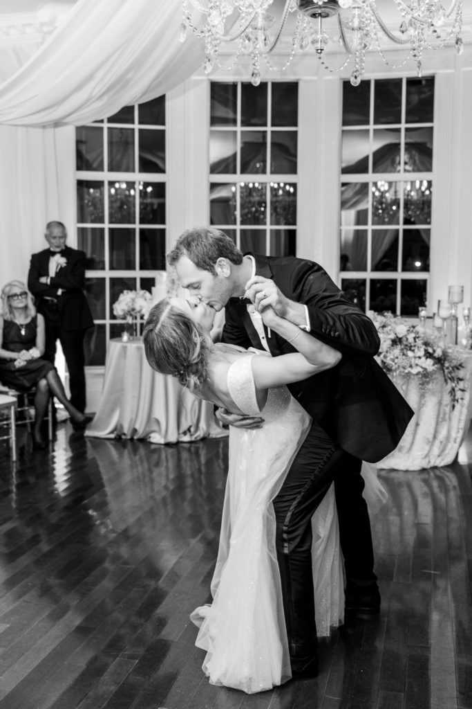 Groom dip kisses bride during first dance at wedding for Luxmore Grande Wedding