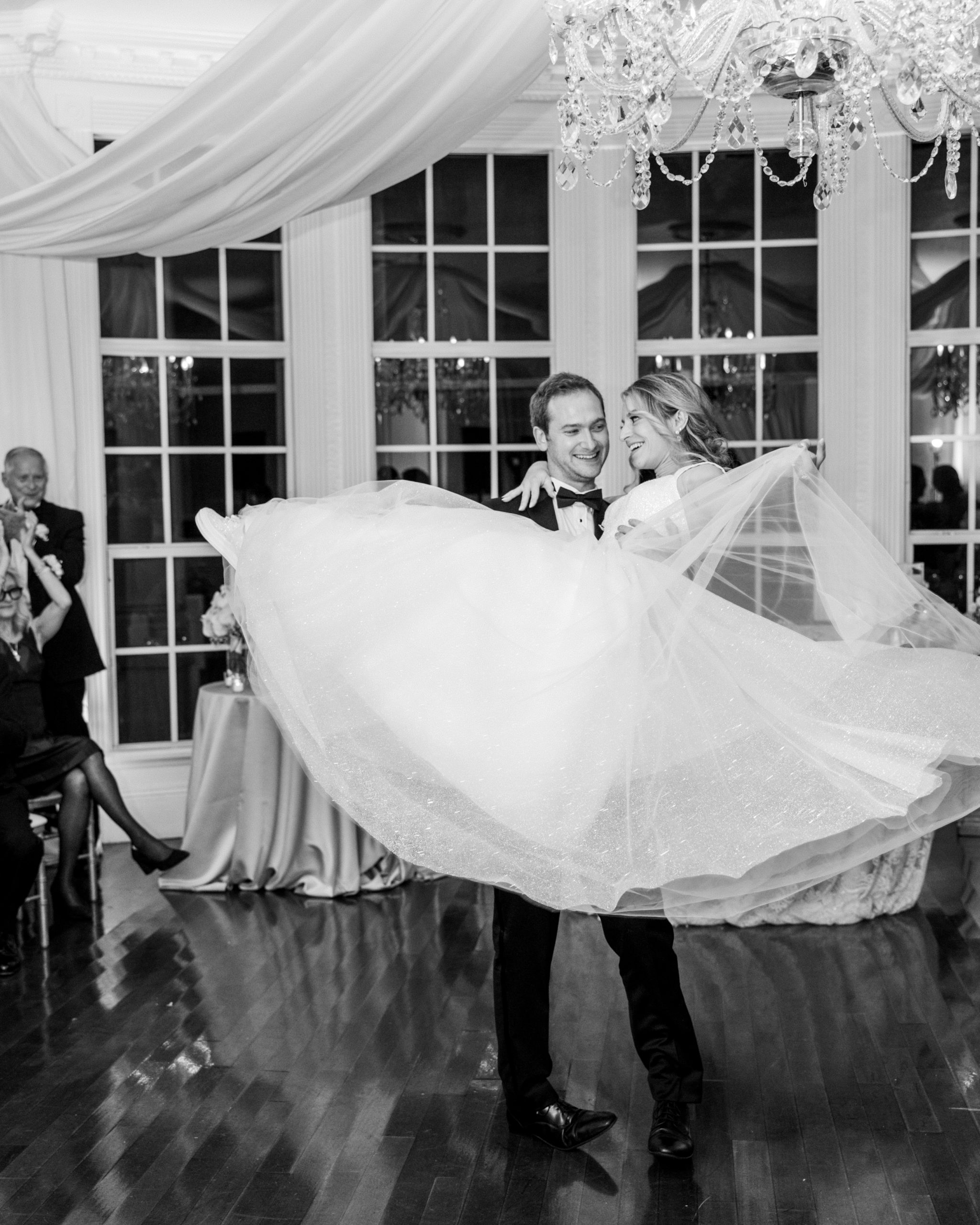 Groom picks up bride during first dance at wedding reception and they smile for Luxmore Grande Wedding