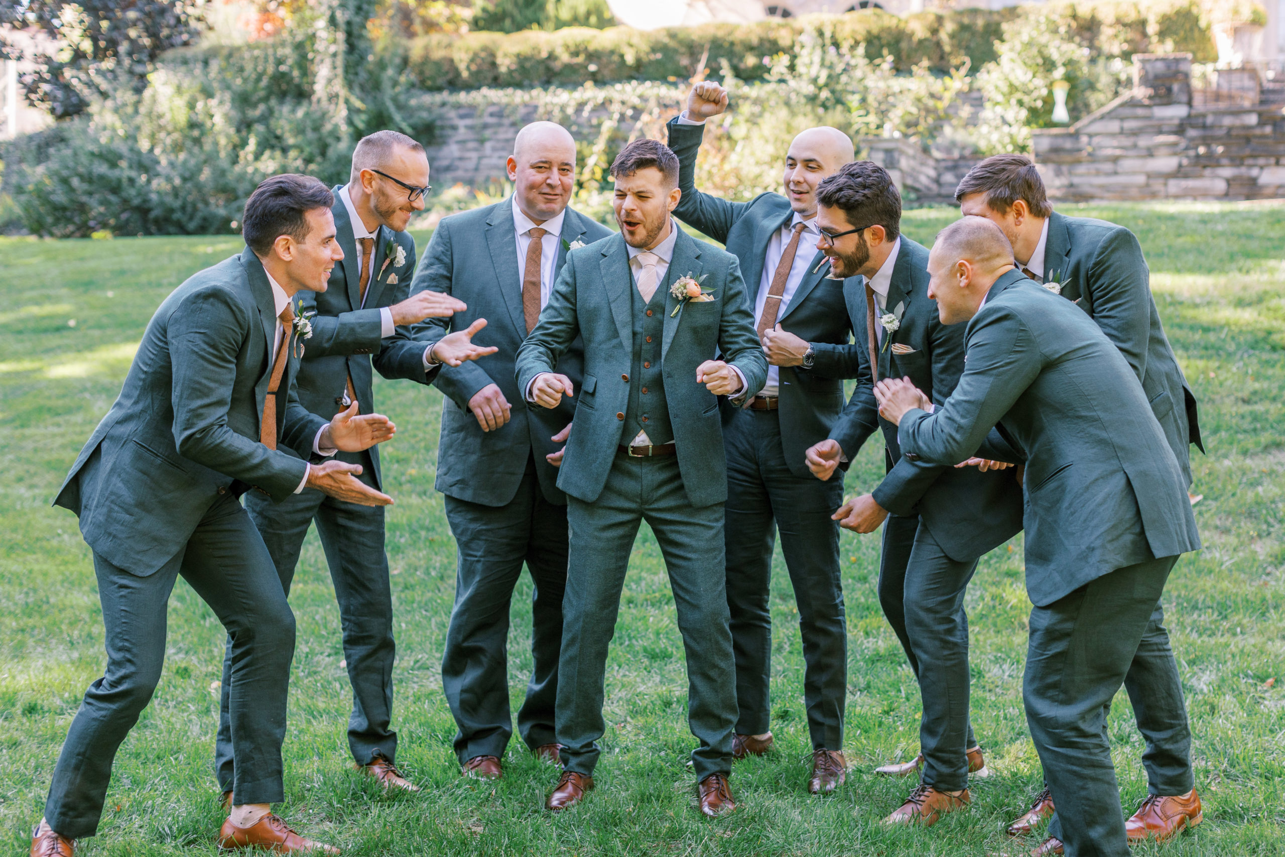 Groomsmen hype groom up on lawn before wedding for philadelphia wedding photographer