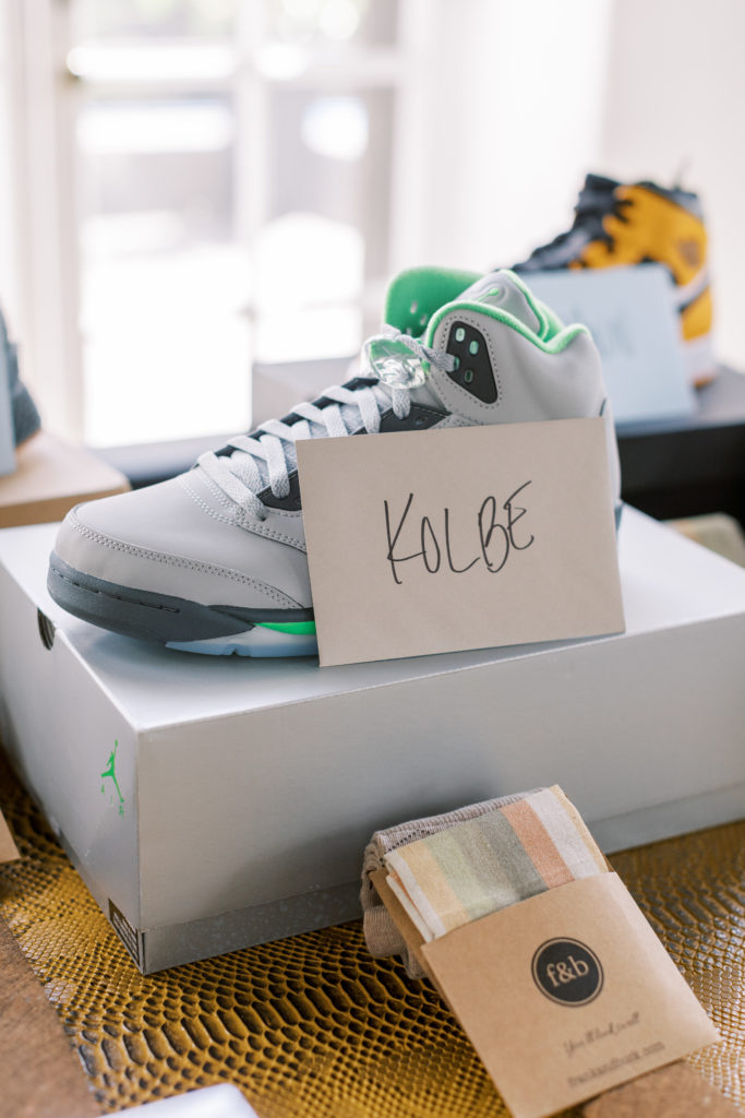 Grey and green men's sneakers on top of box with letter to Kolbe for philadelphia wedding photographer