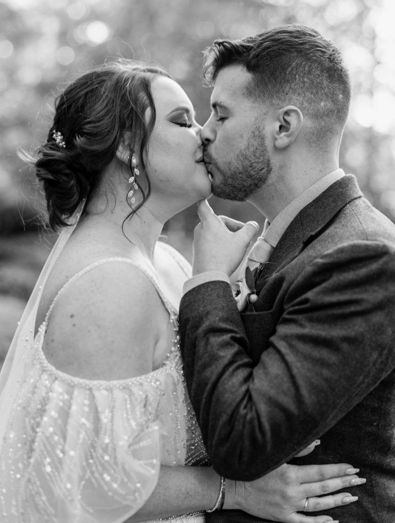 Bride and groom share a kiss and embrace 