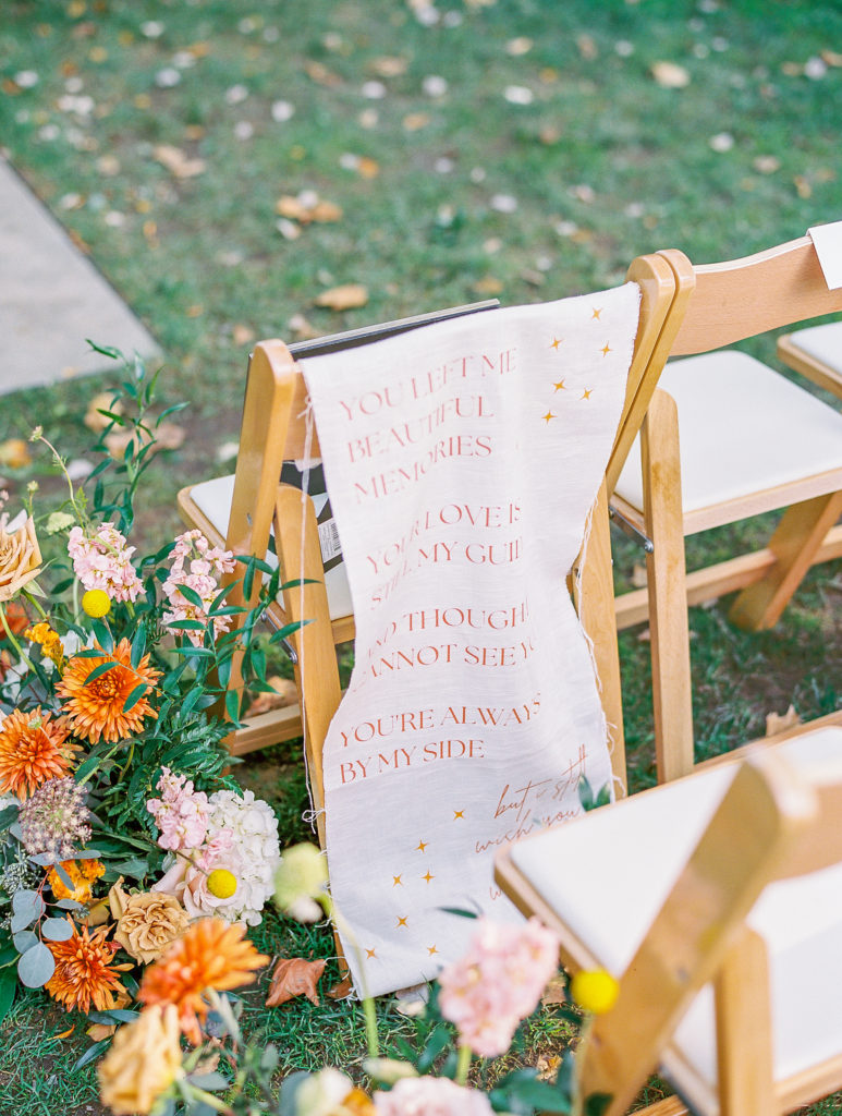 Ceremony chairs with banner and flowers on wood chairs for philadelphia wedding photographer