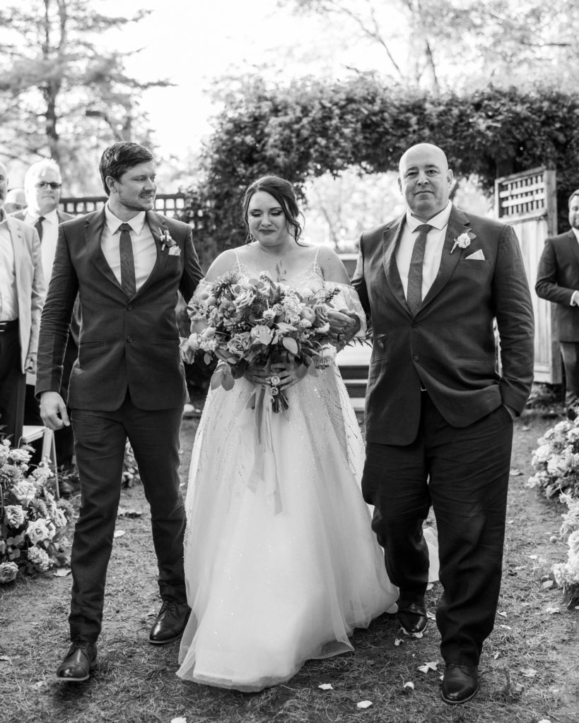 Bride walks down the aisle with father and brother 