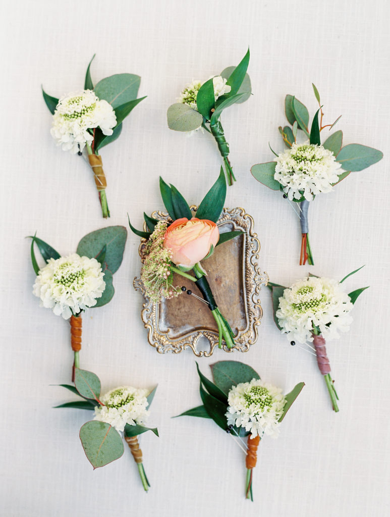 White and peach boutonnières for wedding day 