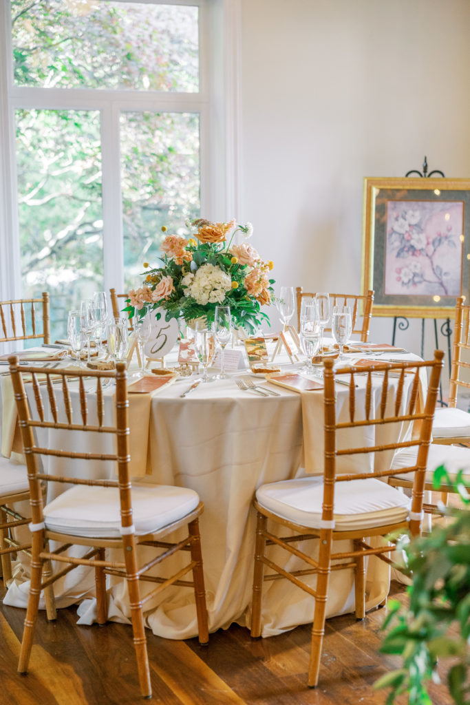 Wedding reception round tables with orange and white flower center pieces 