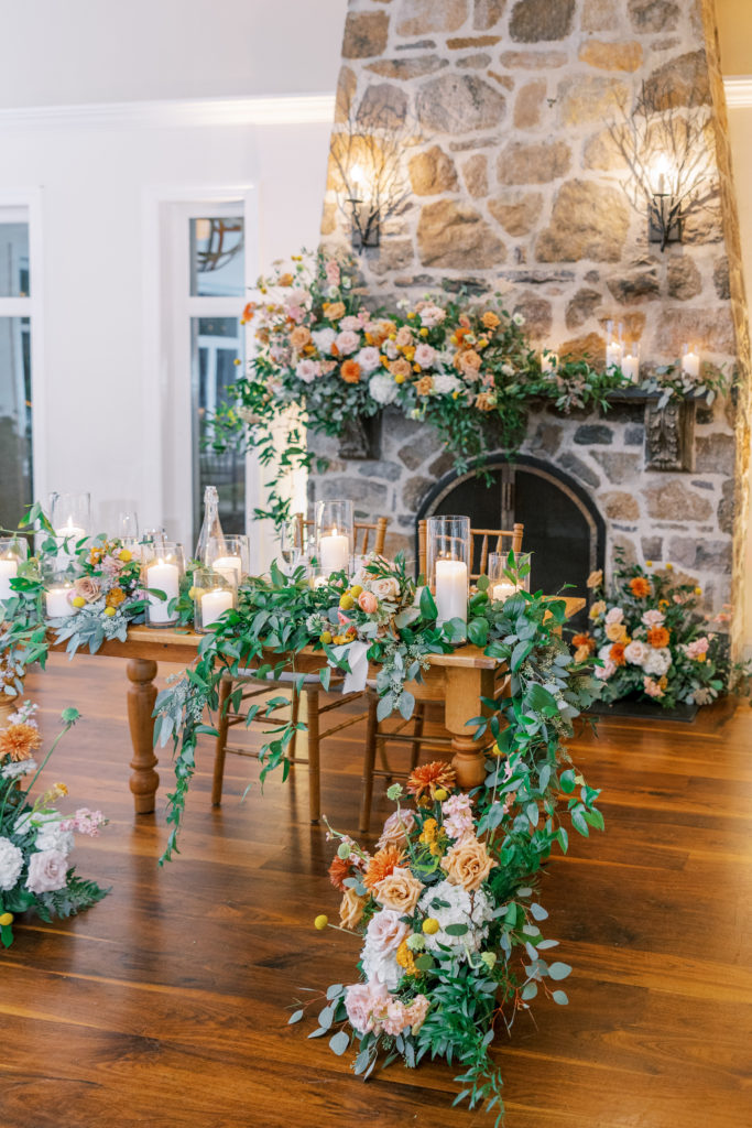 Bride and groom's reception table covered with orange, pink, and greenery for philadelphia wedding photographer