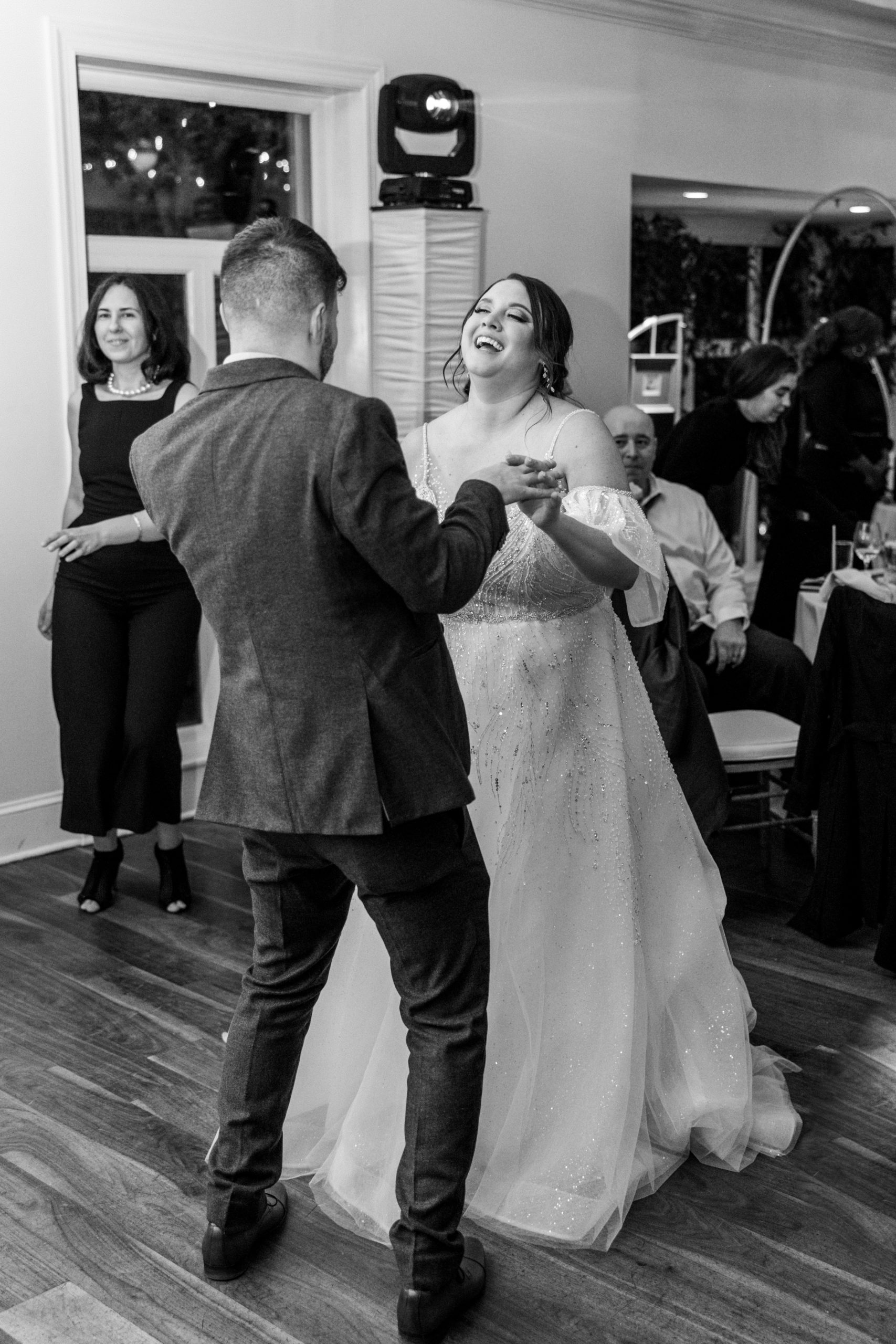 Bride and groom hold hands dancing at wedding reception at this pomme radnor wedding