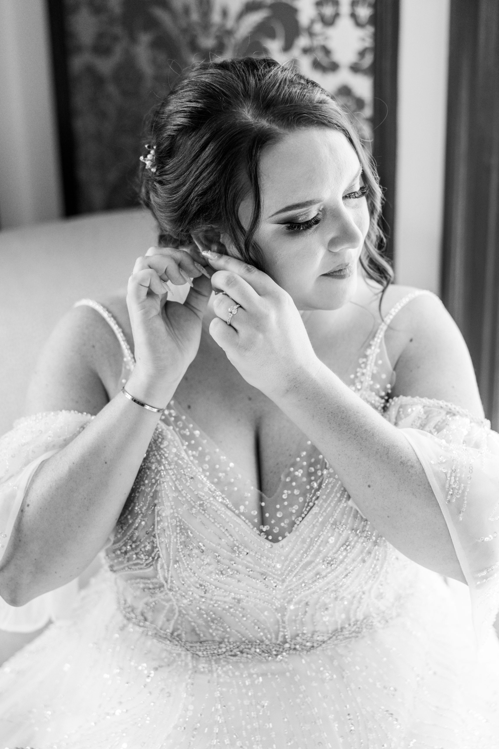 Bride puts earrings on and looks down at this pomme radnor wedding