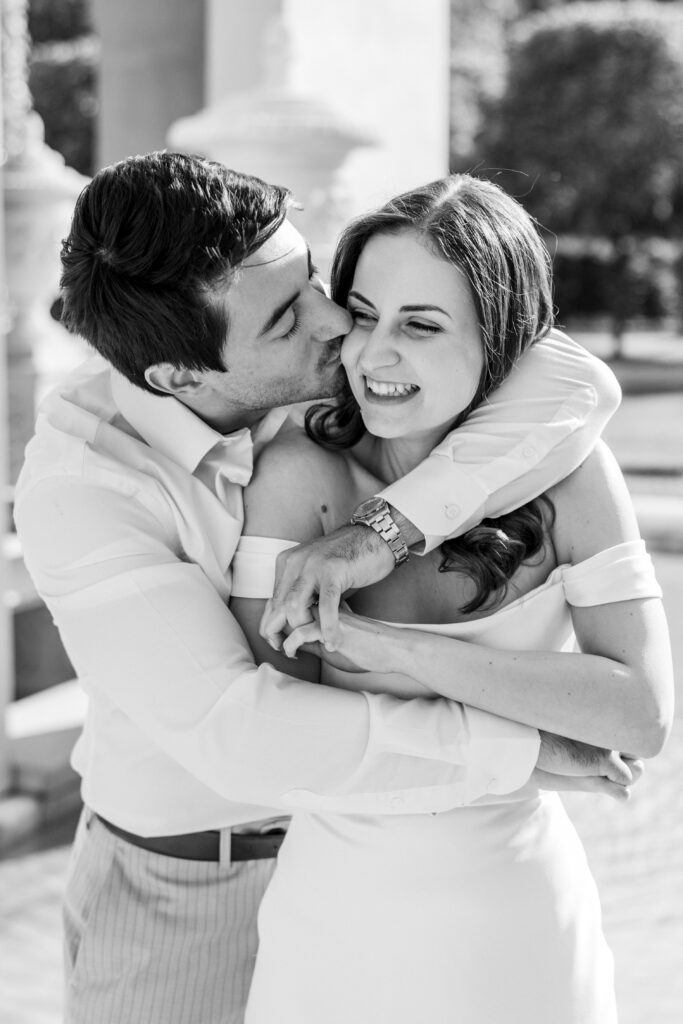 couple embraces with arms wrapped around each other in black and white