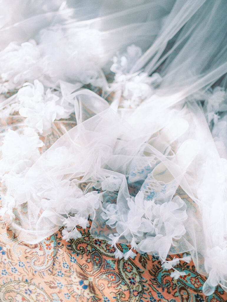 ruffled bridal veil and shoes in dappled sunlight at luxury charleston wedding