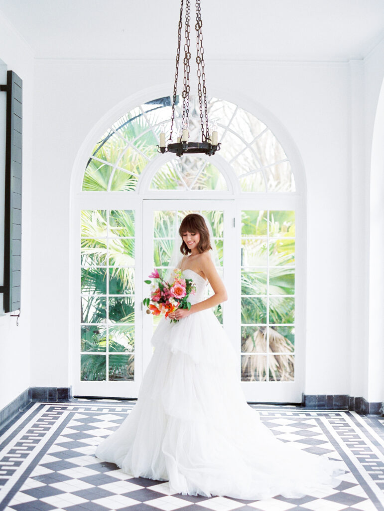 Lowdnes Grove Wedding by destination film wedding photographer Katie Trauffer Photography - bridal portrait in front of large window with colorful flowers