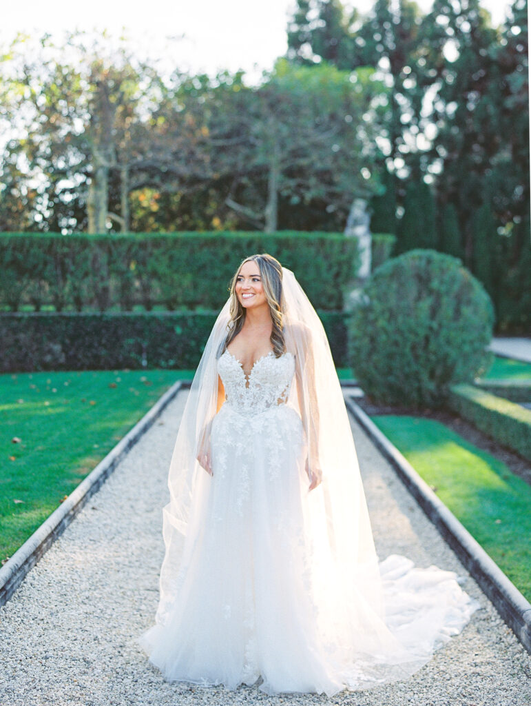 bride stands glowing in sunlight at oheka wedding