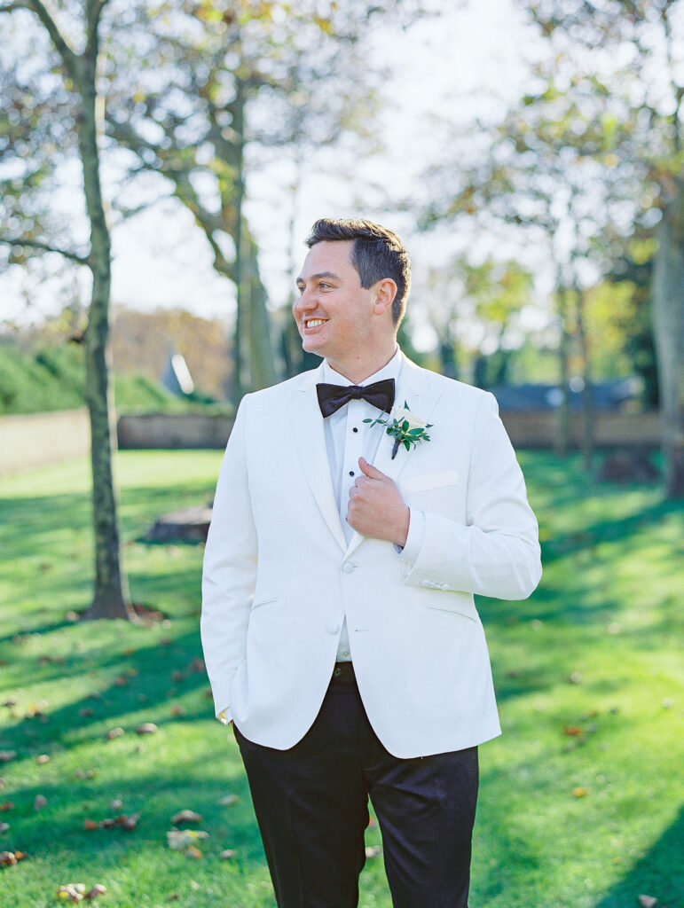 groom in white tux at oheka wedding