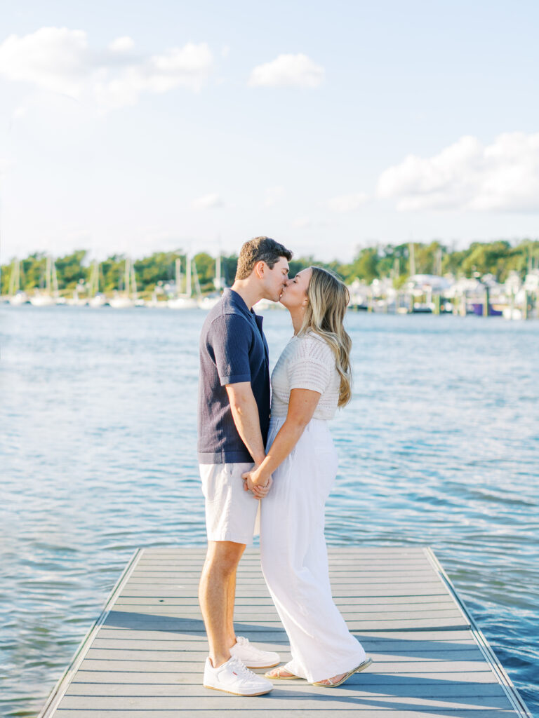 couple kiss on dock on sunny day