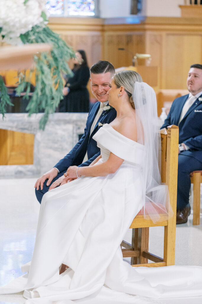 bride and groom laugh together during Catholic ceremony