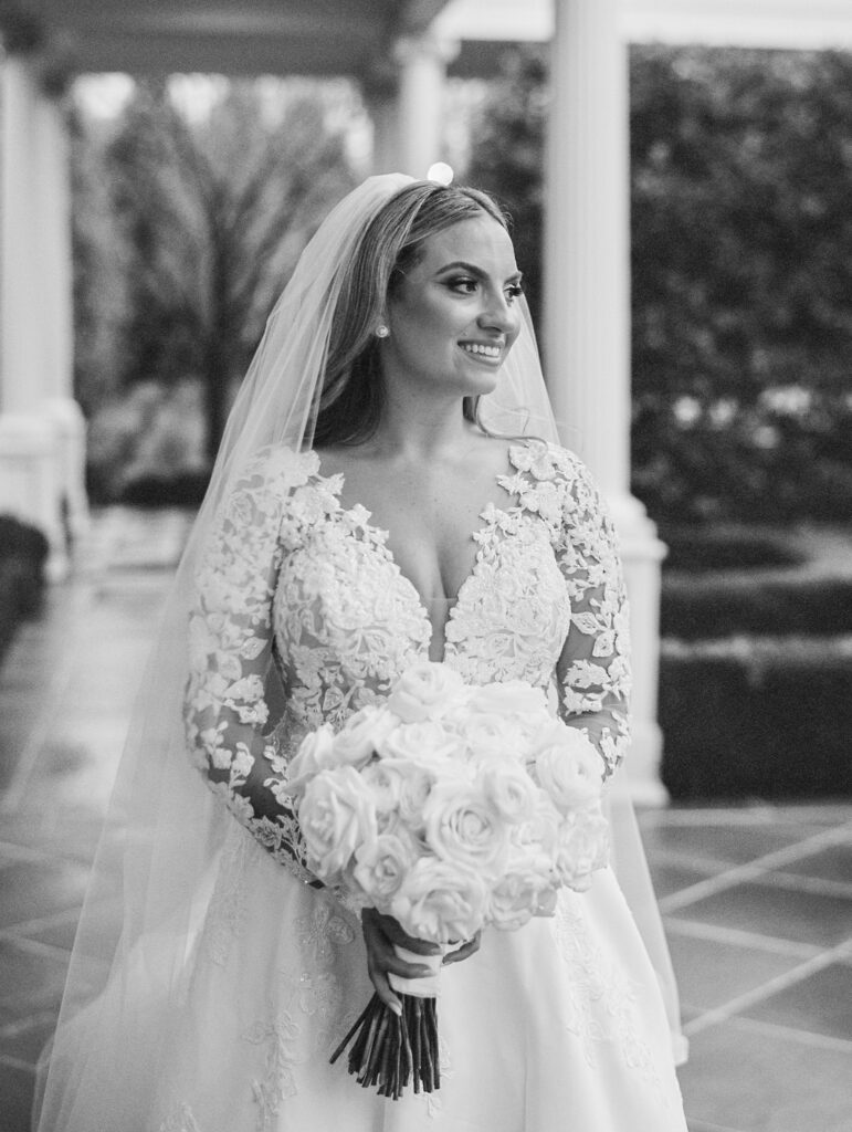 black and white image of beautiful bride amid white columns
