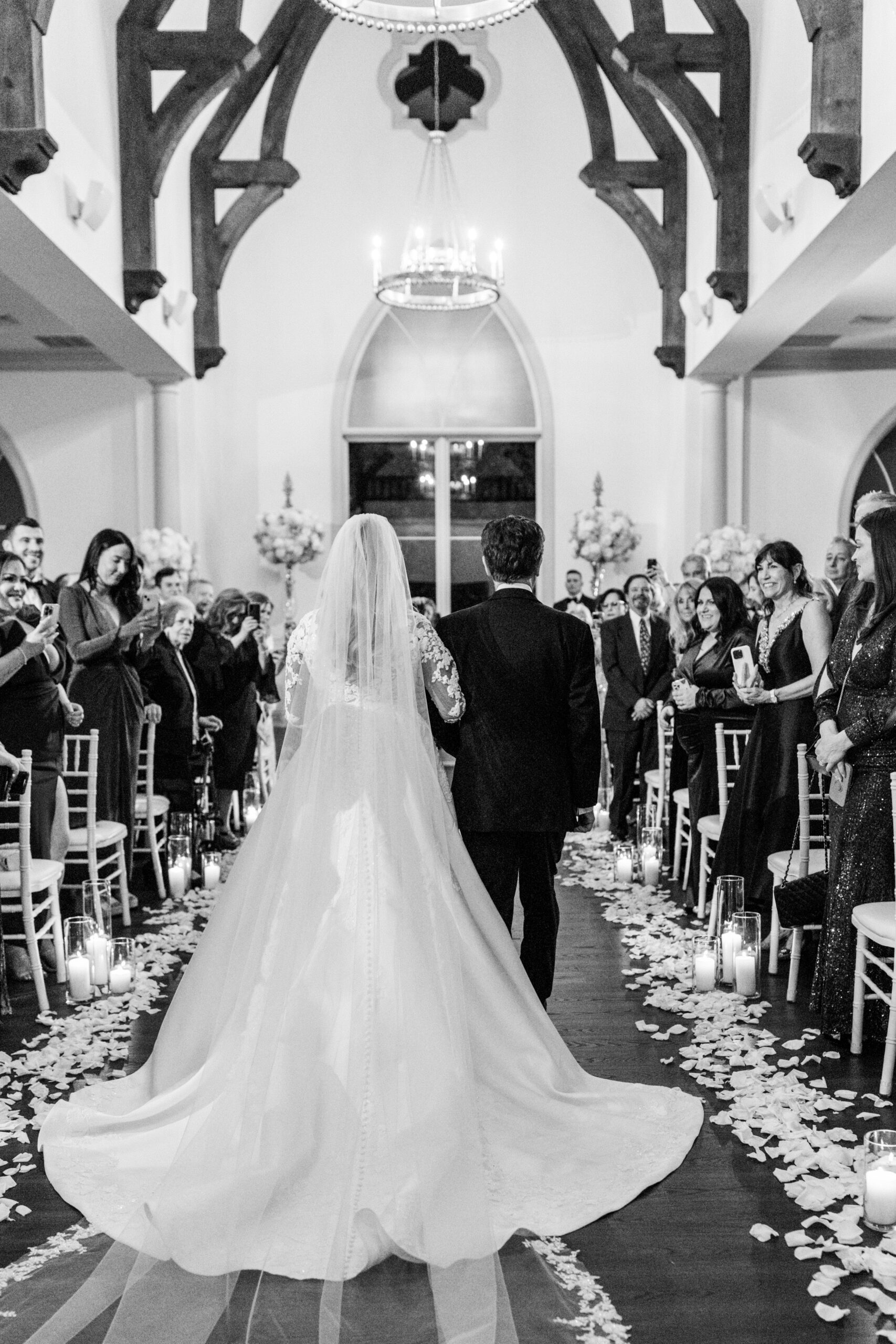 bride walks down aisle with father in beautiful chapel